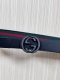 This reversible belt features red and green webbing and black cowhide leather,