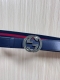 This reversible belt features red and blue webbing and blue cowhide leather, pai