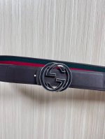This reversible belt features red and green webbing and dark brown cowhide leath