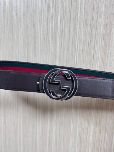 This reversible belt features red and green webbing and dark brown cowhide leath