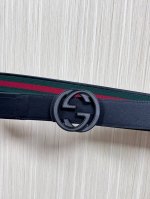 This reversible belt features red and green webbing and black cowhide leather,