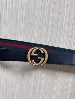 This reversible belt features red and green webbing and black cowhide leather,
