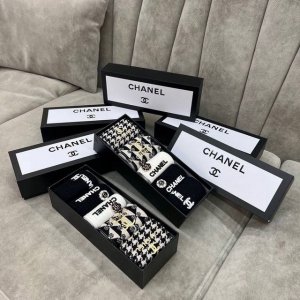 Packaged as a box of five pairs of Chanel mid-calf socks. Sizes 35-40. Material