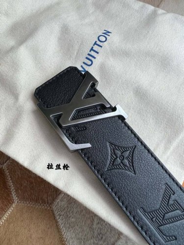 Fashionable Louis Vuitton belt. Black leather embossed belt with lettering metal