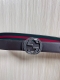 This reversible belt features red and green webbing and dark brown cowhide leath