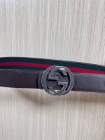 This reversible belt features red and green webbing and dark brown cowhide leath