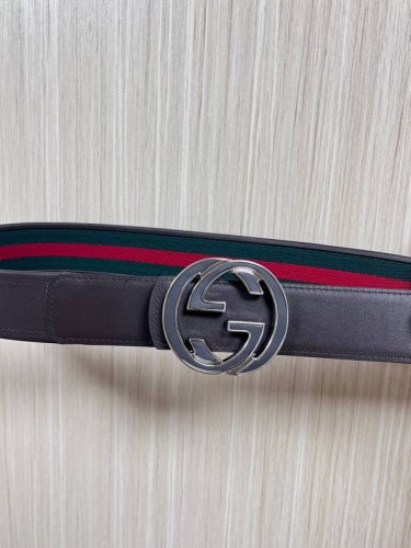 This reversible belt features red and green webbing and dark brown cowhide leath