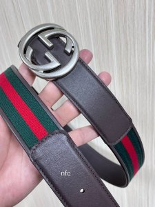 This reversible belt features red and green webbing and dark brown cowhide leath