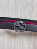 This reversible belt features red and green webbing and dark brown cowhide leath