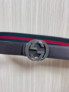 This reversible belt features red and green webbing and dark brown cowhide leath